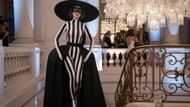 Black and white striped jumpsuit and statement hat (Image via Instagram/@emilyinparis)
